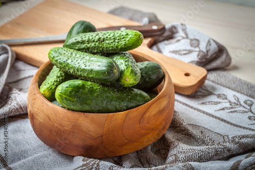 Fresh cucumbers in a wooden bowl.