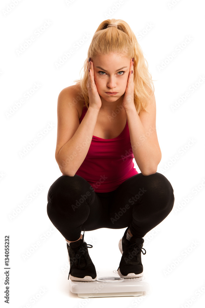 Worried woman standing on scale measuring weight Worried woman standing on scale measuring weight