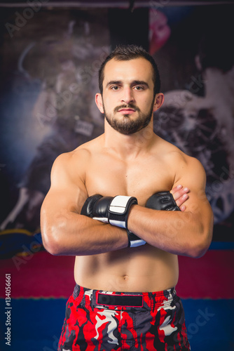 Mixed martial arts fighter standing with his arms crossed in a close up shot facing camera