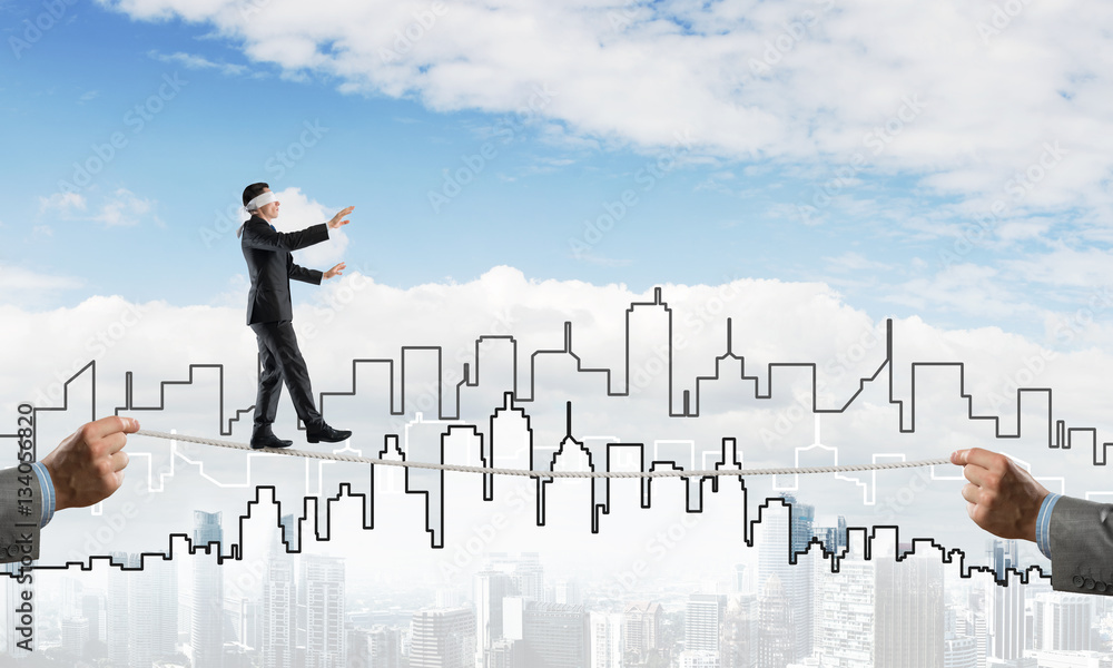 Business concept of risk support and assistance with man balancing on rope Business concept of risk support and assistance with man balancing on rope