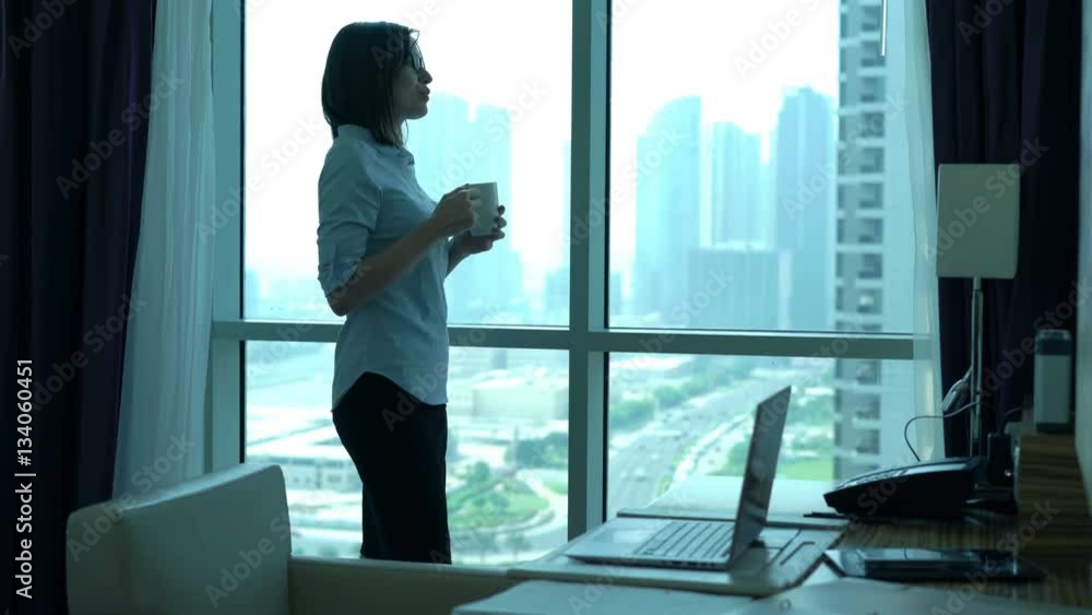 Young businesswoman drinking coffee and admire view from window in office
Young businesswoman drinking coffee and admire view from window in office