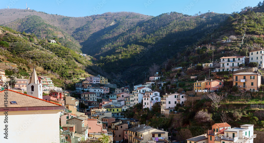 Village of Riomaggiore town with houses, located between mountains at Cinque Terre national park, Italy