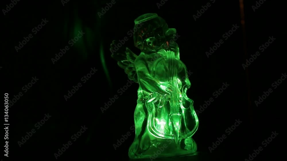 Little angel playing the violin. Light shines in the darkness Little angel playing the violin. Light shines in the darkness