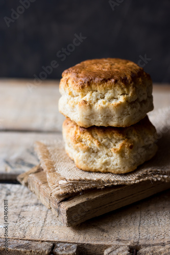 Cuadro en lienzo Stack of homemade scones on burlap on vintage wood table, black wall, rustic kit