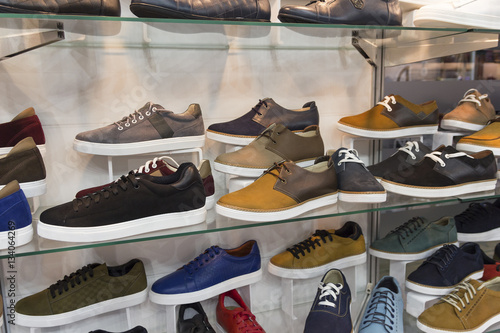 Variety of men's shoes in the shop window. Sale