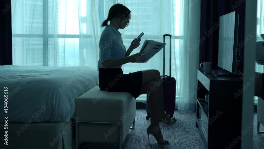 Businesswoman working with documents and smartphone sitting in hotel room
Businesswoman working with documents and smartphone sitting in hotel room