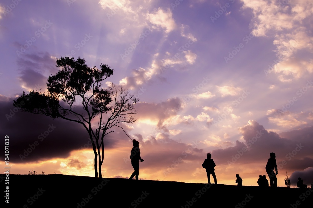 Silhouette of people walking on the hill with dramatic sky Silhouette of people walking on the hill with dramatic sky