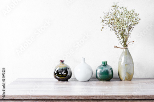 Decorative ceramic vases on wooden table, vintage tone