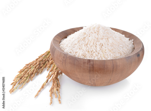 white rice on the wooden plate and rice plant , uncooked raw