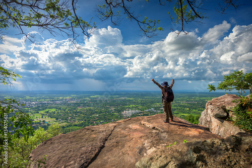 Young man traveler on cliff with beautiful landscape