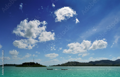 Long tail boat and Green Island with name Coconut Island at Phuket in Thailand. Travel around Asia theme background