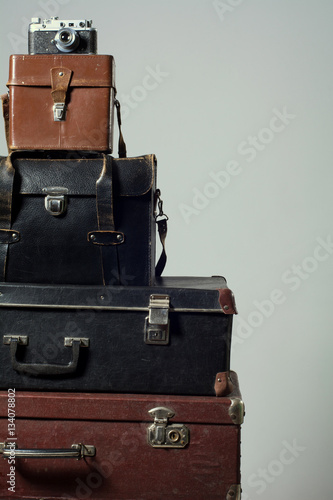 Stack of vintage shabby suitcases and camera