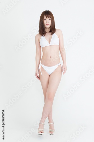 白いビキニの水着を着た若い女性の画像 この画像はスタジオで撮影しています 背景は白です Foto De Stock Adobe Stock