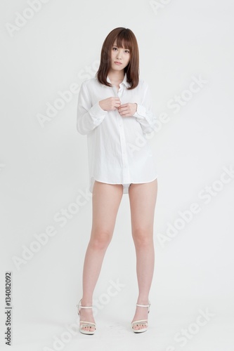Wallpaper Mural 白いシャツを着た女性。女性は足の素肌を見せています。スタジオ撮影。白背景。 Torontodigital.ca