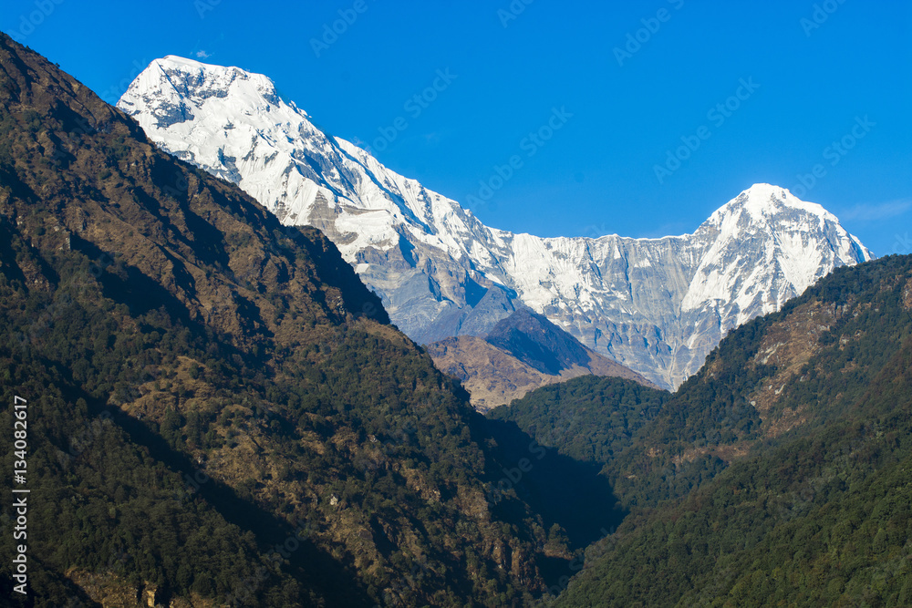 Mountain peaks with snow on blue sky background in Nepal