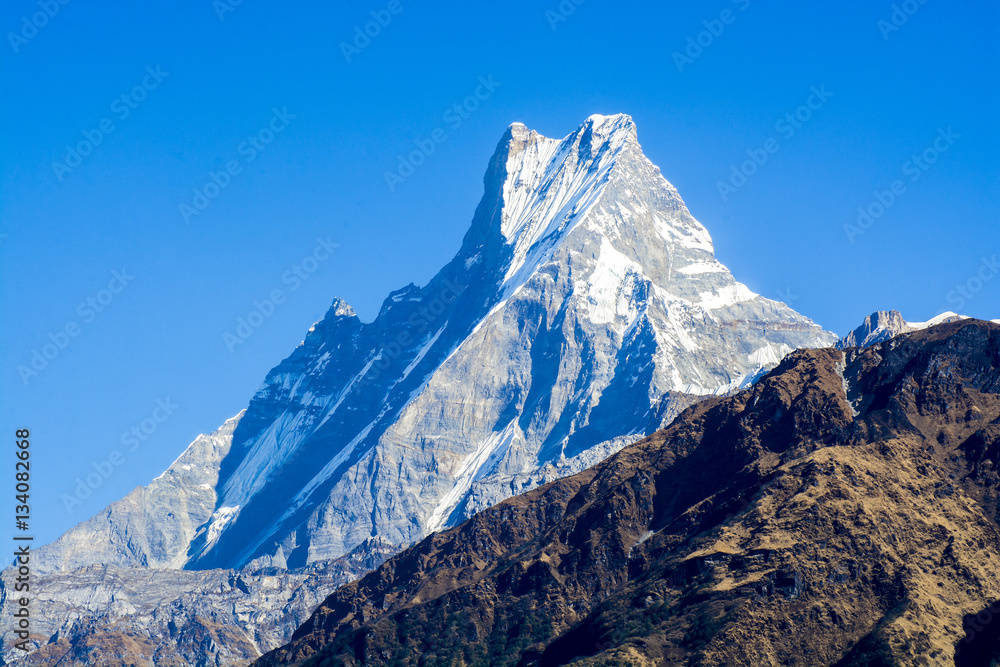 Mountain peaks with snow on blue sky background in Nepal