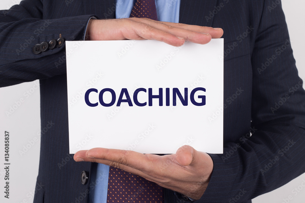 Man showing paper with COACHING text Man showing paper with COACHING text