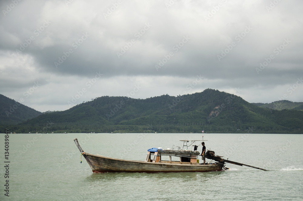 Asian thai people driving wooden motor boat on the sea for send