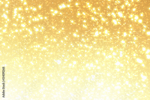 Golden sparkles or glitter lights. Festive gold background. Defocused circles bokeh or particles