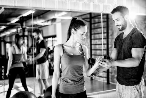 Female on training with instructor. Working out with dumbbells.