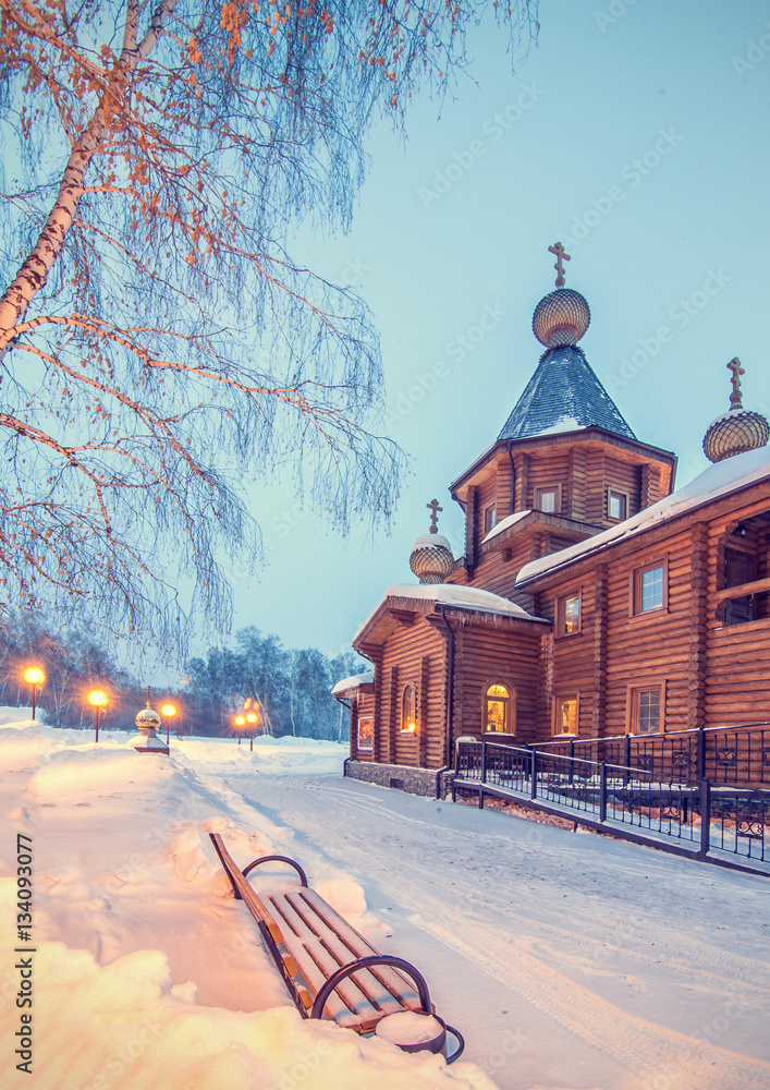 winter night landscape with old rural wooden Church and bench un