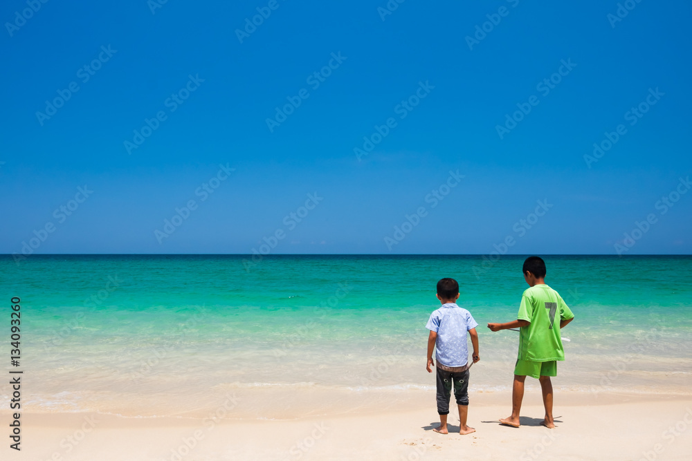 Two boys standing by the sea. Surin Beach, Phuket, Thailand. Two boys standing by the sea. Surin Beach, Phuket, Thailand.