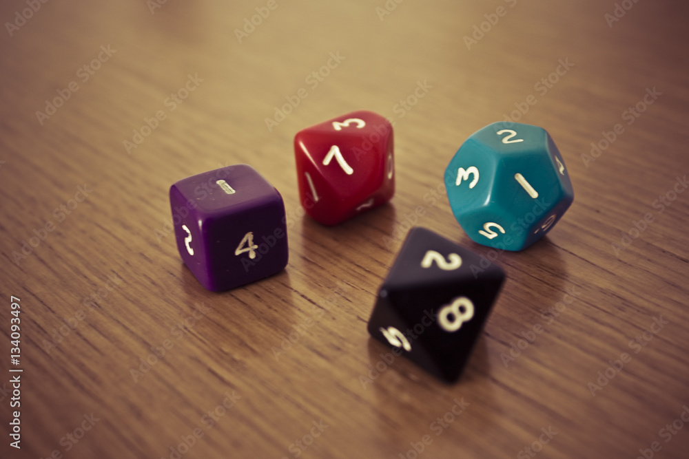 Colored polyhedral playing dice on wooden table Colored polyhedral playing dice on wooden table