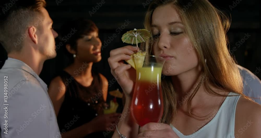 Beautiful women interacting while having a glass of cocktail in bar Beautiful women interacting while having a glass of cocktail in bar