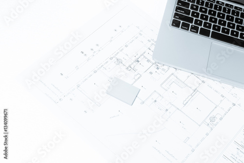 notebook over house construction blueprint with blue tone effect