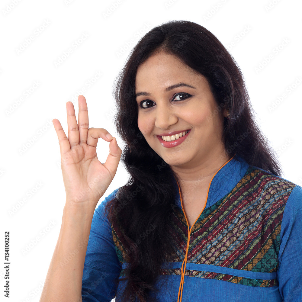 Happy young woman showing OK gesture against a white background Happy young woman showing OK gesture against a white background