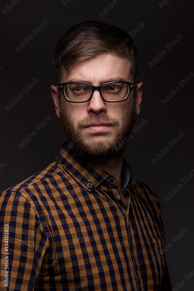 man with a beard wearing glasses on black background. large portrait man with a beard wearing glasses on black background. large portrait