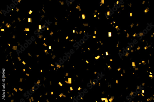 falling gold glitter foil confetti,  on black background, holiday and festive fun © donfiore
