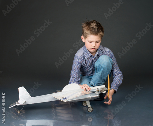 Kid playing with handmade plane glider. Hobby concept.