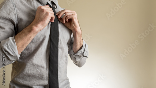 Foto Man adjusting his black necktie