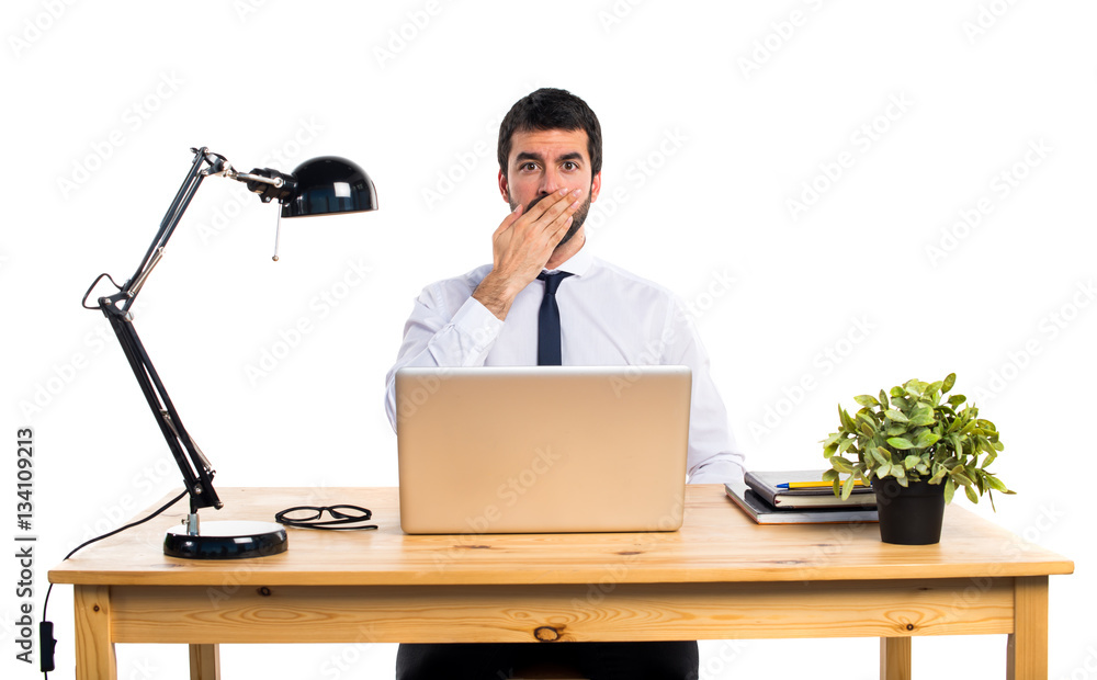 Businessman in his office covering his mouth Businessman in his office covering his mouth