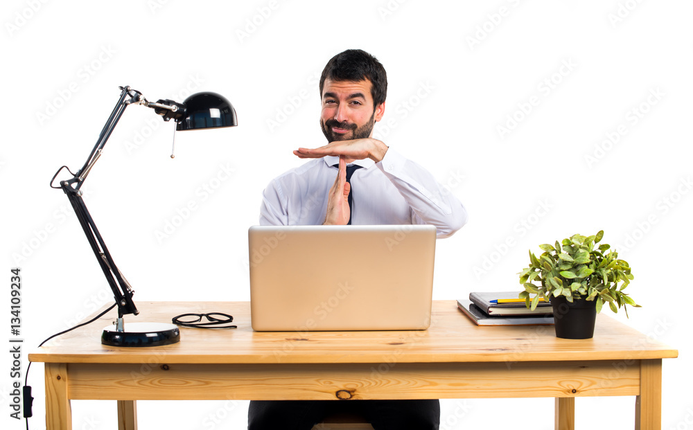 Businessman in his office making time out gesture Businessman in his office making time out gesture