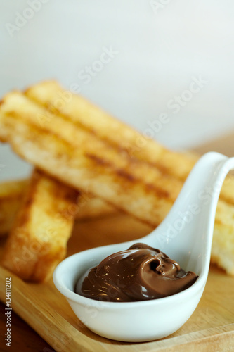 Recipe French Toast Sticks  with hazelnut spread on wooden table background