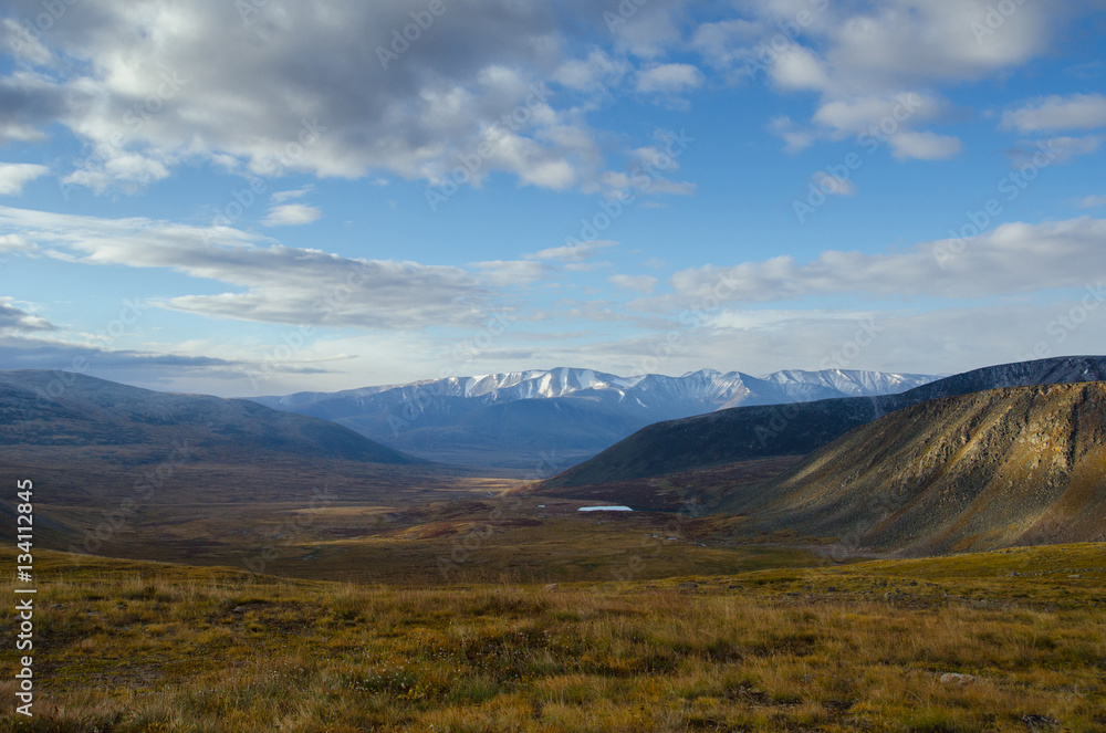 Wildlife Altai. The river, mountains and sky with clouds in summ Wildlife Altai. The river, mountains and sky with clouds in summ
