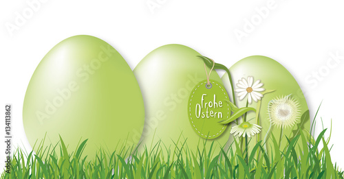 Grüne Ostereier im Gras mit Blumendeko und Anhänger