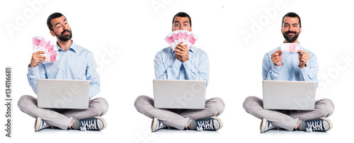 Man with laptop taking a lot of money © luismolinero