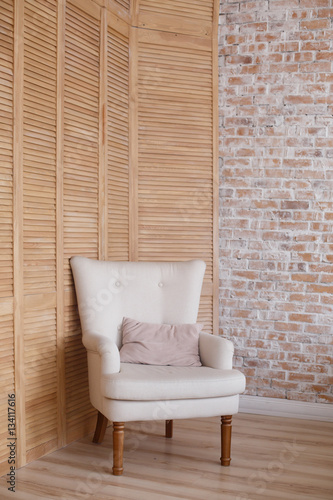 soft armchair near brick wall. Arm-chair with fabric upholstery