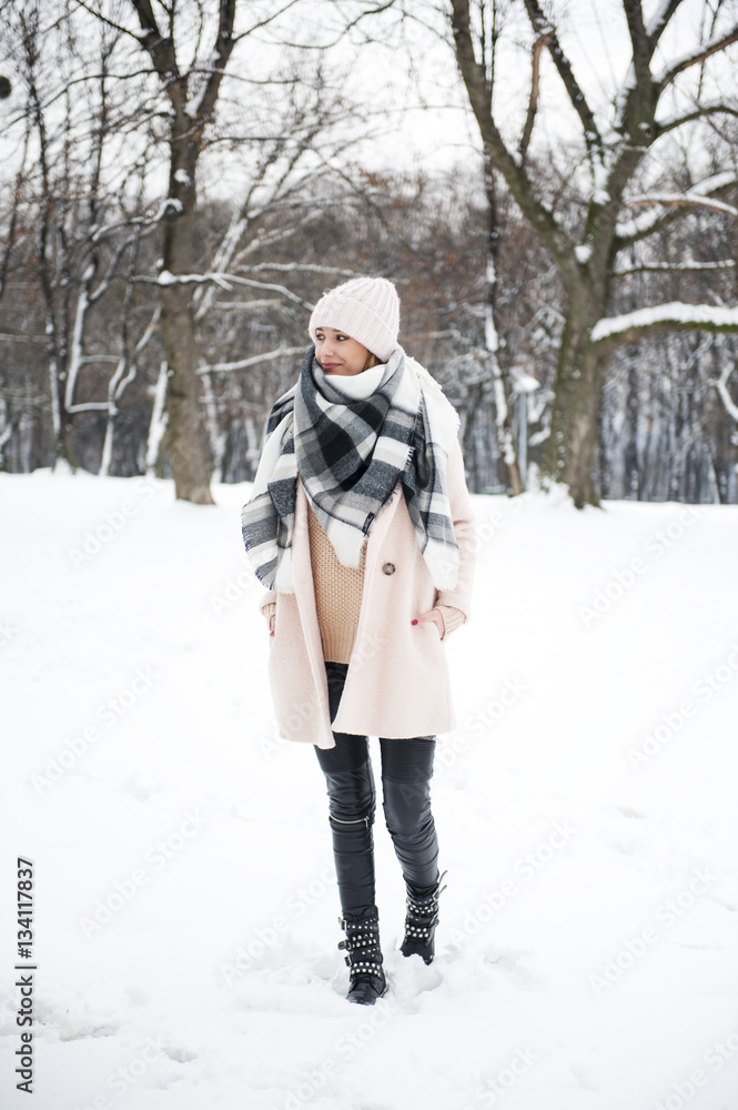 A young woman in a park full of snow