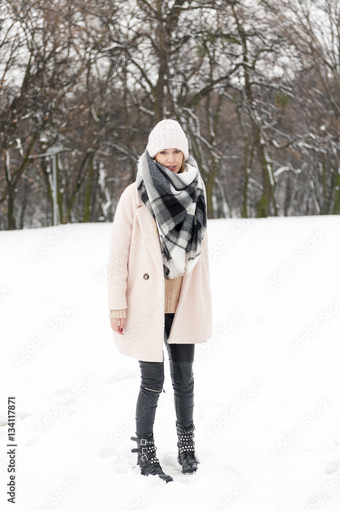 Obraz premium A young woman in a park full of snow
