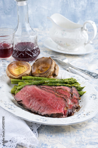 Roast Beef with Green Asparagus and Yorkshire Pudding as close-up on a plate