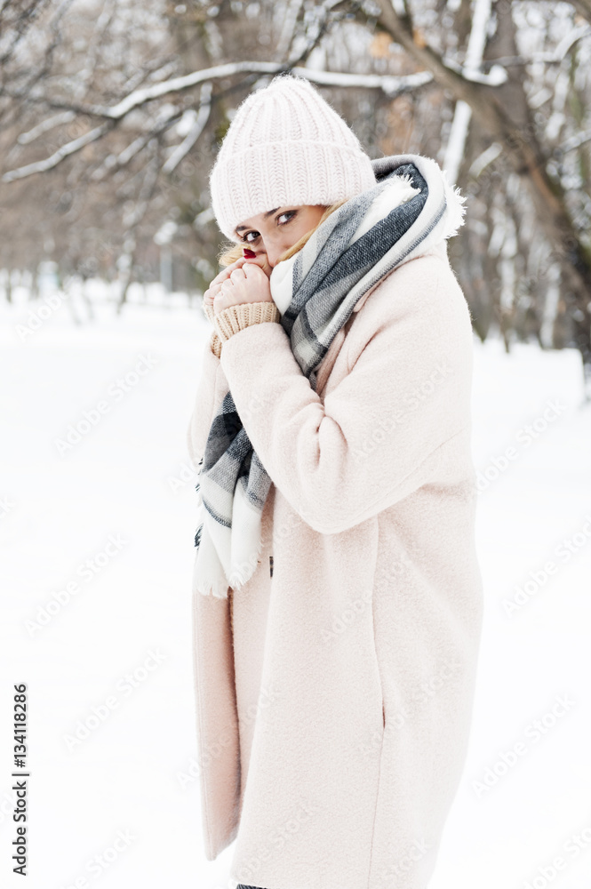 A young woman in a park full of snow A young woman in a park full of snow