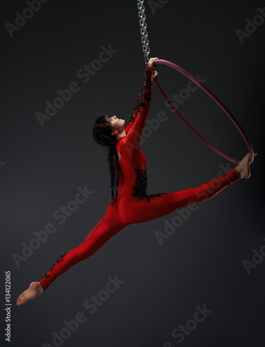 Young pretty gymnast with red hoop studio portrait
