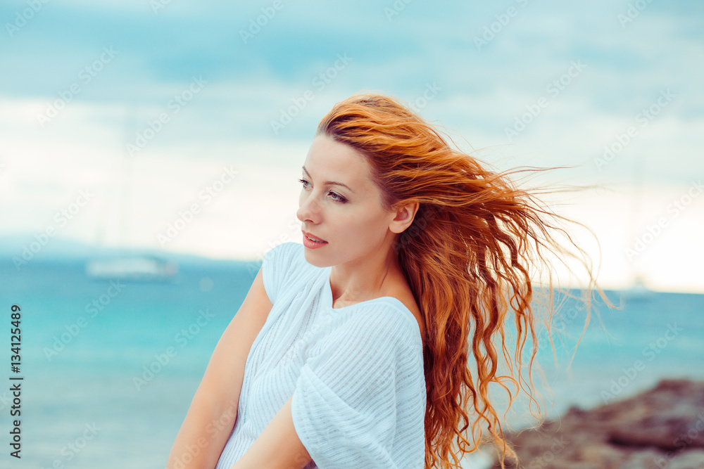 Side profile portrait of young serious thoughtful woman standing by the ocean Side profile portrait of young serious thoughtful woman standing by the ocean