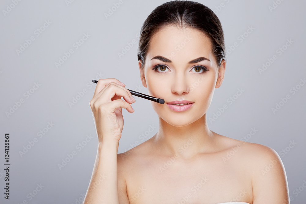 Model touching face with brush