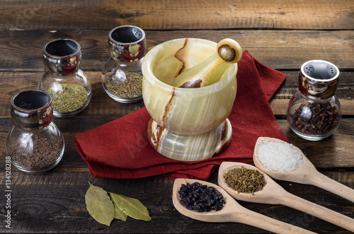 spices in spoons and Jar with mortar on wodeen background photo