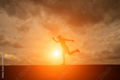 Silhouette of happy people running in sunset.